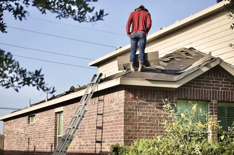 Professional roofer working on a residential roof in Brewery District